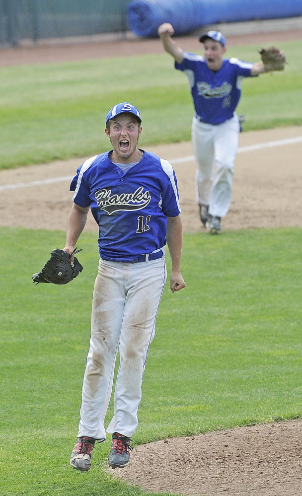 Sacopee Valley starting pitcher Anthony Haskell celebrates along with third baseman Kyle Jordan, background, after the Hawks beat St. Dominic 4-2 to win the Western C regional baseball title Tuesday at St. Joseph’s College in Standish.