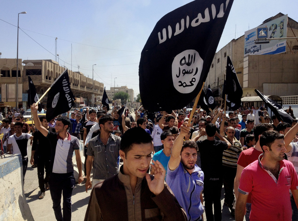 Demonstrators chant pro-al-Qaida-inspired Islamic State of Iraq and the Levant (ISIL) as they carry al-Qaida flags in front of the provincial government headquarters in Mosul, 225 miles (360 kilometers) northwest of Baghdad, Iraq, Monday, June 16, 2014. Sunni militants captured a key northern Iraqi town along the highway to Syria early on Monday, compounding the woes of Iraq’s Shiite-led government a week after it lost a vast swath of territory to the insurgents in the country’s north.
