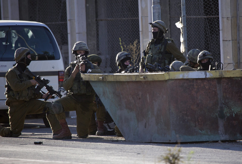 Israeli soldiers take positions Tuesday during a search for three missing Israeli teenagers in the West Bank city of Hebron.