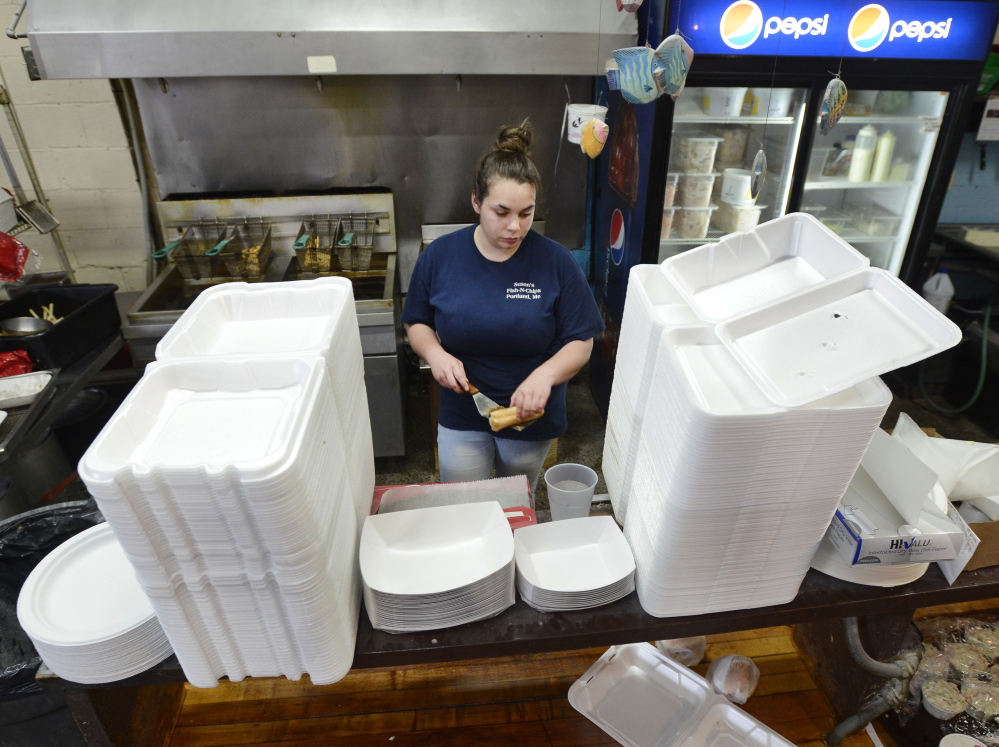 Manager Lindsey Schwarz at Susan’s Fish-N-Chips is framed Tuesday by Styrofoam take-out containers that the restaurant will be banned from using starting next April. 