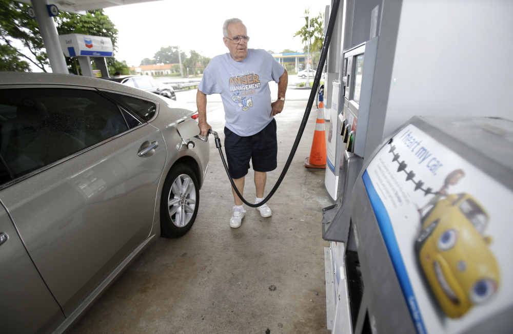 Marty Mascio pumps gasoline into his car at a Chevron gasoline station in Pembroke Pines, Fla. Americans are driving less per capita and cars are more fuel efficient, keeping federal tax revenues fairly flat.