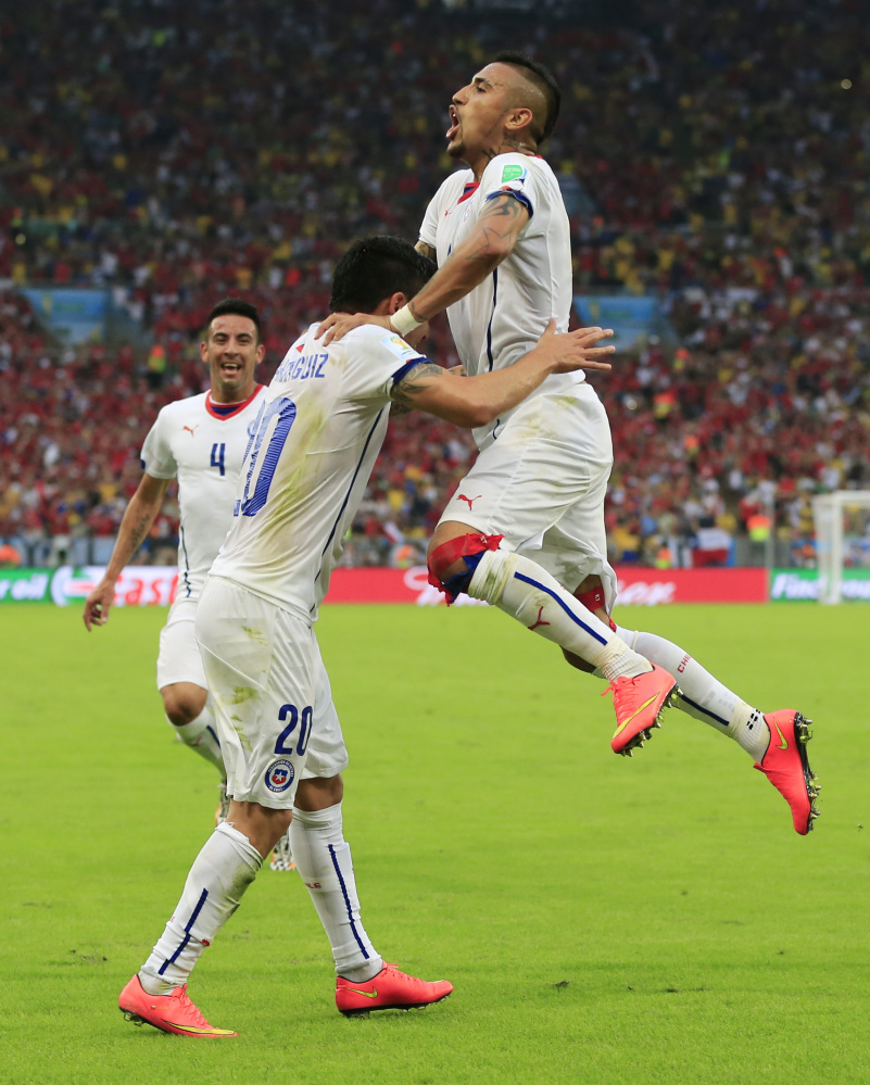 Chile's Charles Aranguiz, left, celebrates after scoring his side's second goal during the group B World Cup soccer match between Spain and Chile at the Maracana Stadium in Rio de Janeiro, Brazil, Wednesday, June 18, 2014.  (AP Photo/Bernat Armangue