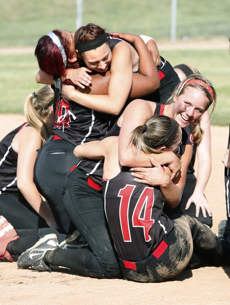 Wells High School player Lauren Bame hugs Sophie Lamb as Jordan Agger, upper left, celebrates with Nodine Webster after defeating Cape Elizabeth High School for the Western Class B championship at Saint Joseph’s College in Standish on Wednesday.