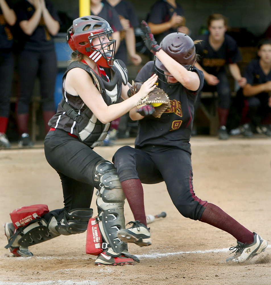 Wells High School catcher Meghan Young holds on to the ball while colliding with Elise Flathers of Cape Elizabeth High School during their Western Class B championship softball game at Saint Joseph’s College in Standish on Wednesday.