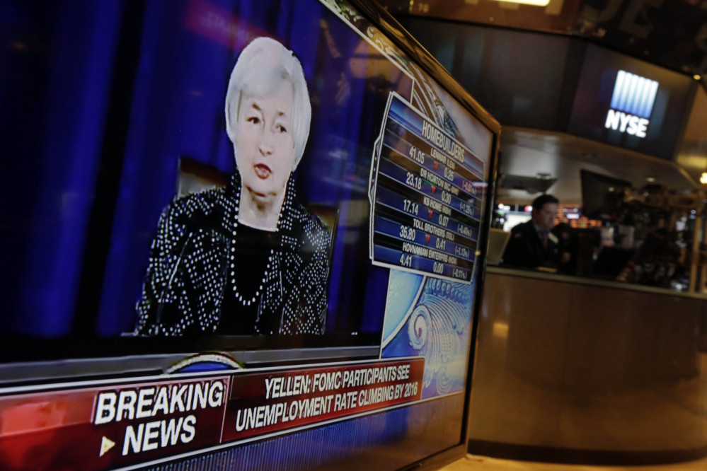 Federal Reserve Chair Janet Yellen’s news conference appears on a television monitor on the floor of the New York Stock Exchange, Wednesday, June 18, 2014. The Federal Reserve says it will further slow the pace of its bond purchases because a strengthening U.S. job market needs less support. But it’s offering no clear signal about when it will start raising its benchmark short-term rate.