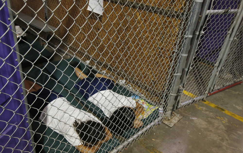 Two female detainees sleep in a holding cell Wednesday at the U.S. Customs and Border Protection placement center in Nogales, Ariz., while awaiting transfer to other shelters.