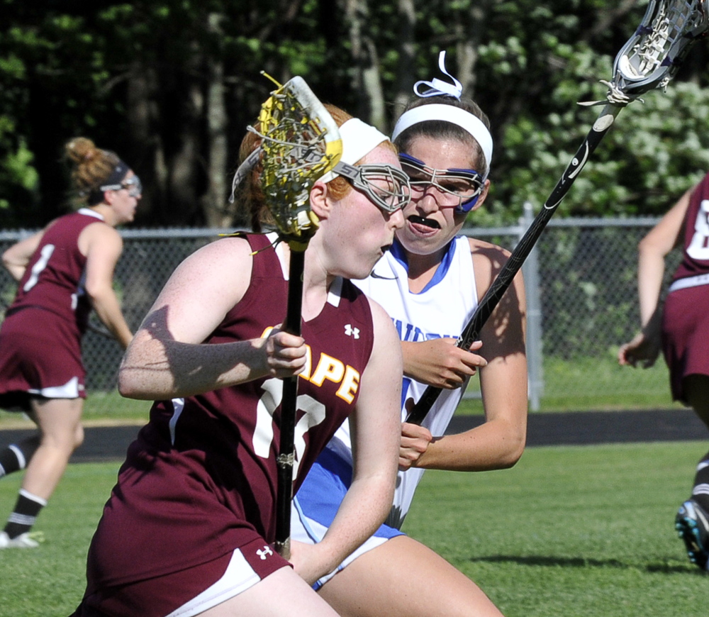Abby McInerney of Cape Elizabeth looks for room past Kennebunk’s Jenny Bush in Wednesday’s Western Class B final at Cape Elizabeth. The Capers prevailed after losing the previous three regional finals.