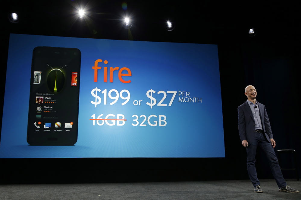 Amazon CEO Jeff Bezos stands next to an image showing the $199 price and depicting a 32GB Amazon Fire smartphone on Wednesday in Seattle.
