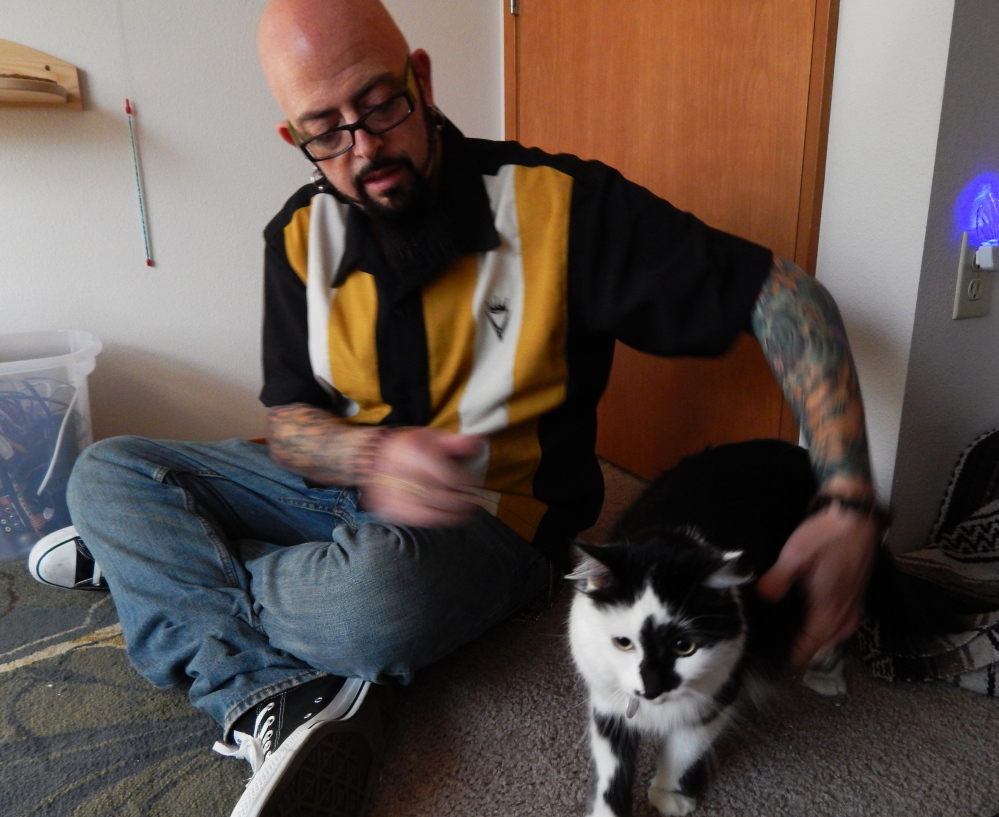 Jackson Galaxy, host of Animal Planet’s “My Cat From Hell,” sits in Portland, Ore., with a cat named Lux, whose owners called 911 after Lux boxed them into a bedroom.