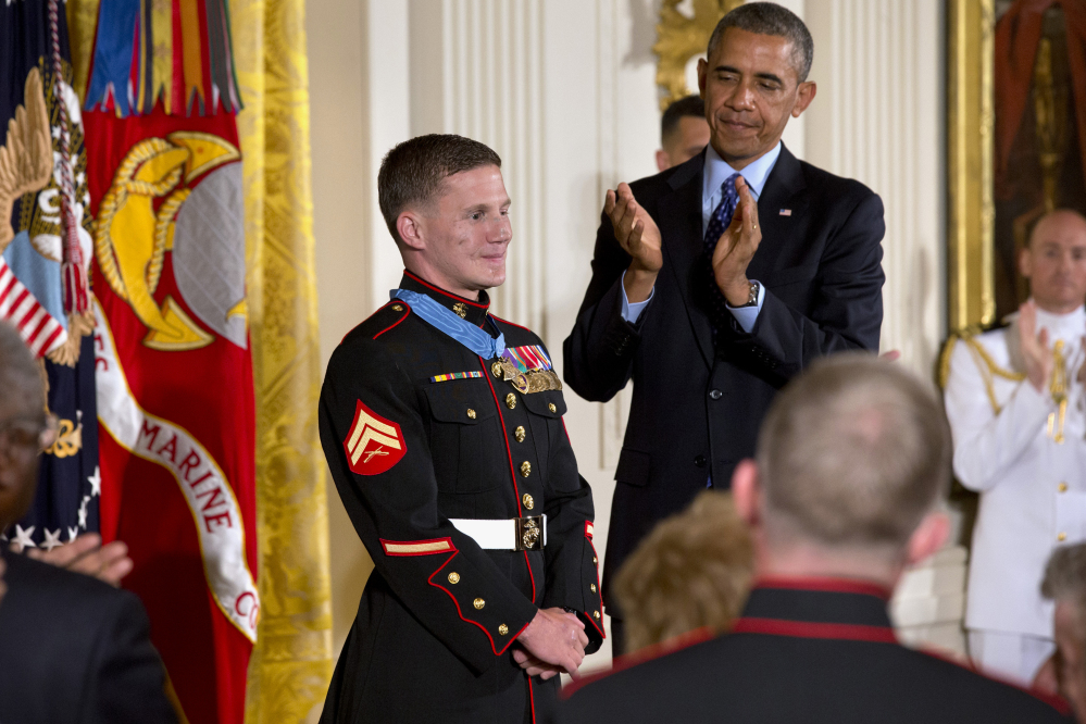 President Barack Obama and the crowd applaud retired Marine Cpl. William “Kyle” Carpenter, 24, left, after awarding him the Medal of Honor for conspicuous gallantry, Thursday, June 19, 2014, during a ceremony in the East Room of the White House in Washington. Carpenter received the Medal of Honor for his courageous actions while serving as an Automatic Rifleman in Helmand Province, Afghanistan.