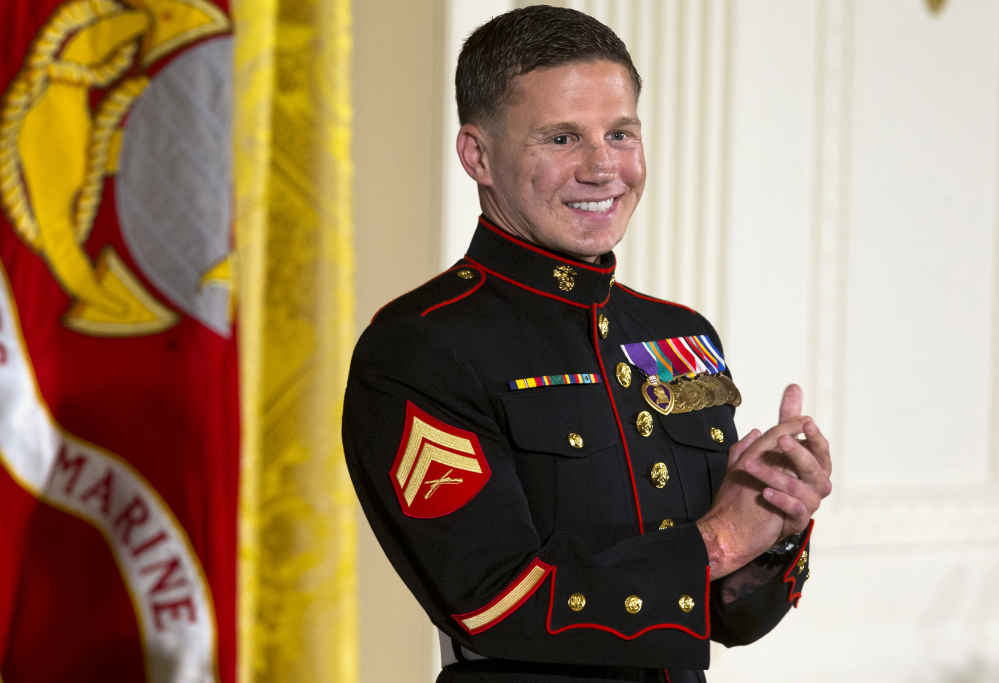 Retired Marine Cpl. William “Kyle” Carpenter applauds his medical team as they stand to be acknowledged by President Barack Obama during a ceremony presenting Carpenter with the Medal of Honor for conspicuous gallantry, Thursday, June 19, 2014.