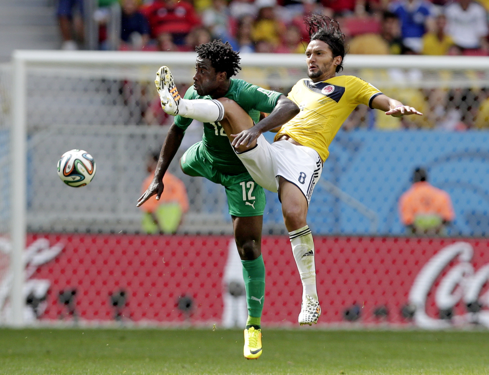 Ivory Coast’s Wilfried Bony (12) and Colombia’s Abel Aguilar (8) battle for the ball.