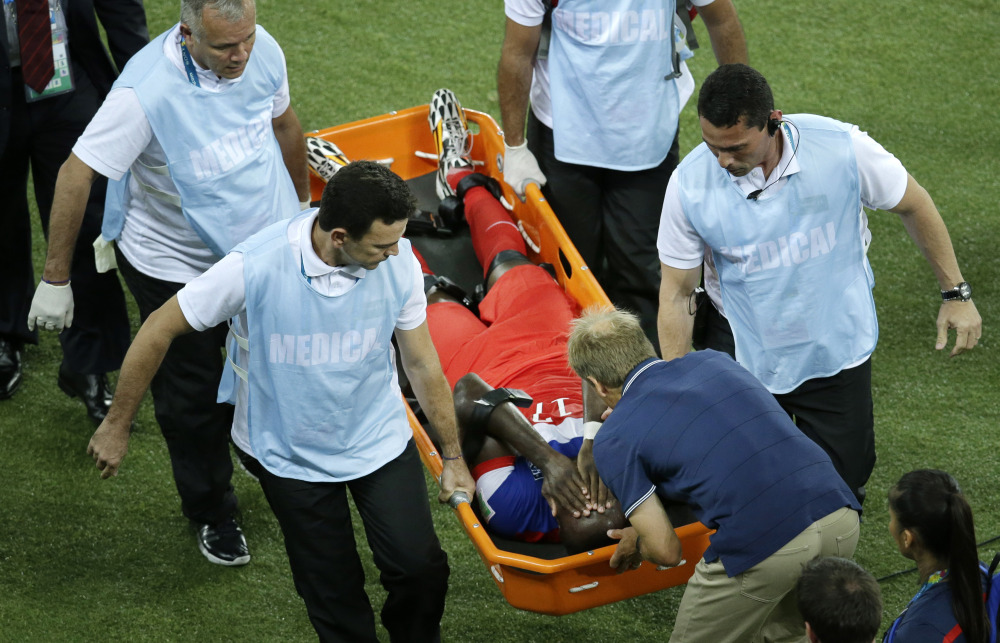 United States’ Jozy Altidore is attended to by head coach Juergen Klinsmann, bottom, as he is carried off the pitch during the group G World Cup soccer match between Ghana and the United States.