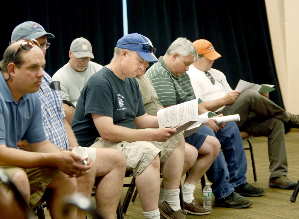 Herring fishermen from Rockland look over informational material during the New England Fishery Management Council meeting at the Holiday Inn by the Bay in Portland. The council voted 10-0 against raising the limit on haddock bycatch to help the herring fleet.