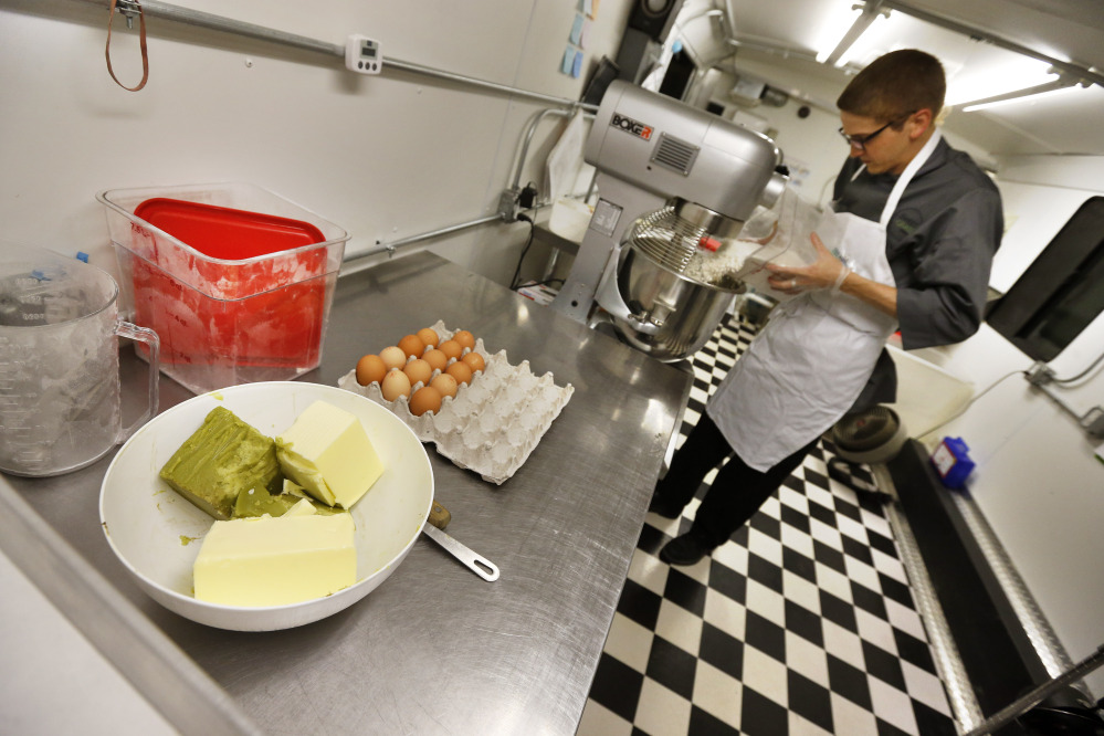 Chef Alex Tretter prepares a batter for peanut butter and jelly cups, with green cannabis-infused “canna butter” in a bowl at left, at Sweet Grass Kitchen, a gourmet marijuana edibles bakery that sells its confections to retail outlets, in Denver.
