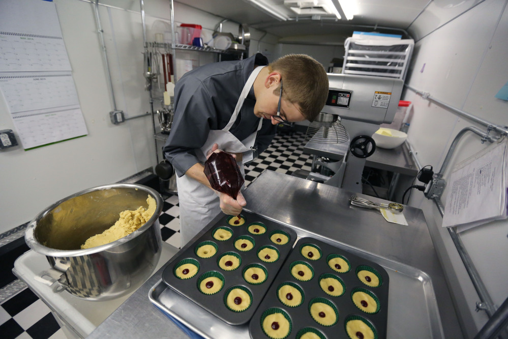 Chef Alex Tretter adds strawberry jam to cannabis-infused peanut butter and jelly cups before baking them at Sweet Grass Kitchen, a gourmet marijuana edibles bakery in Denver.
