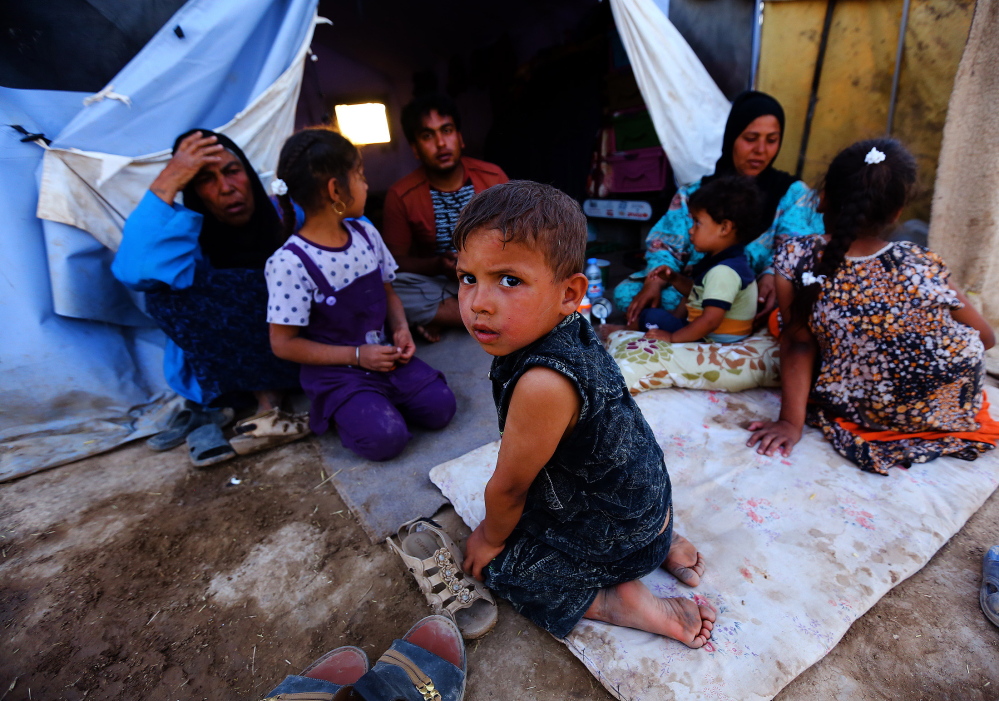 Iraqi refugees sit at the Khazir refugee camp outside Irbil in northern Iraq on Friday.