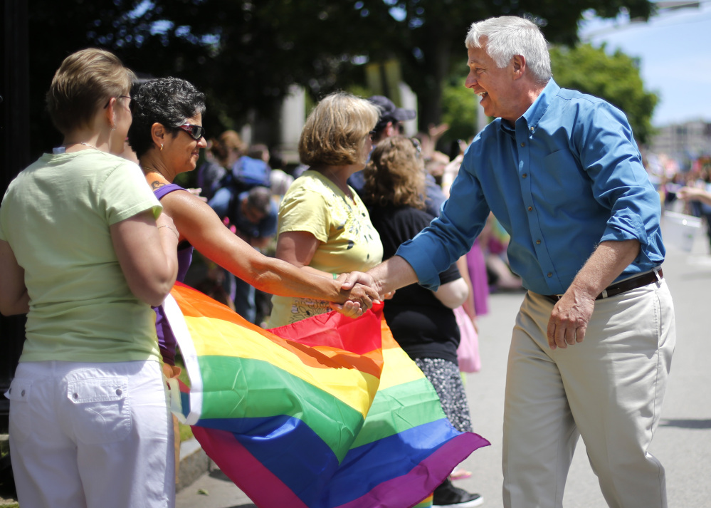 U.S. Rep. Mike Michaud, a Democratic candidate for governor, greets spectators at the Portland Pride Parade on Saturday in Portland.