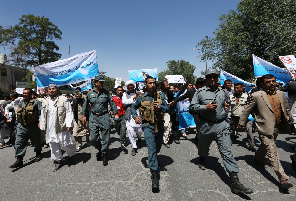 Afghan police officers secure the area as supporters of presidential candidate Abdullah Abdullah hold a protest in Kabul, Afghanistan, on Saturday.