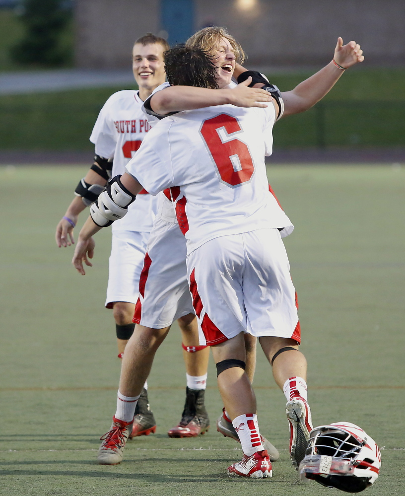 Duncan Preston, who paced the South Portland offense with four goals, hugs goalie T-Moe Hellier after the Red Riots capped a 14-1 season with their first lacrosse state championship.
