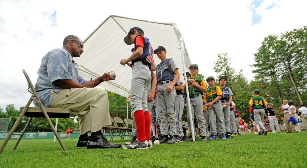 Jim Rice signs baseballs for players during the dedication of Little Fenway Park on Saturday.