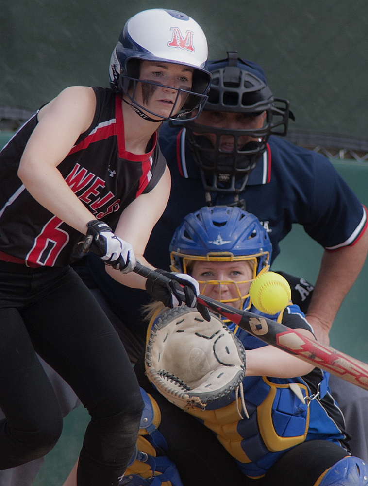 Alison Duplisea of Wells drops a bunt in front of Hermon catcher Shaniah Haskell during the Class B softball state championship game Saturday in Brewer.