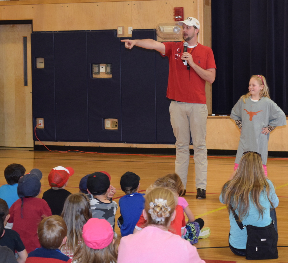 Three-time Olympic gold medalist Ian Crocker addresses Wells Elementary School students in a special assembly recently. Crocker was invited to the school by third-grader Isabella Bazata (right), who detailed the Olympic swimmer’s life as part of a social studies project on famous Mainers.