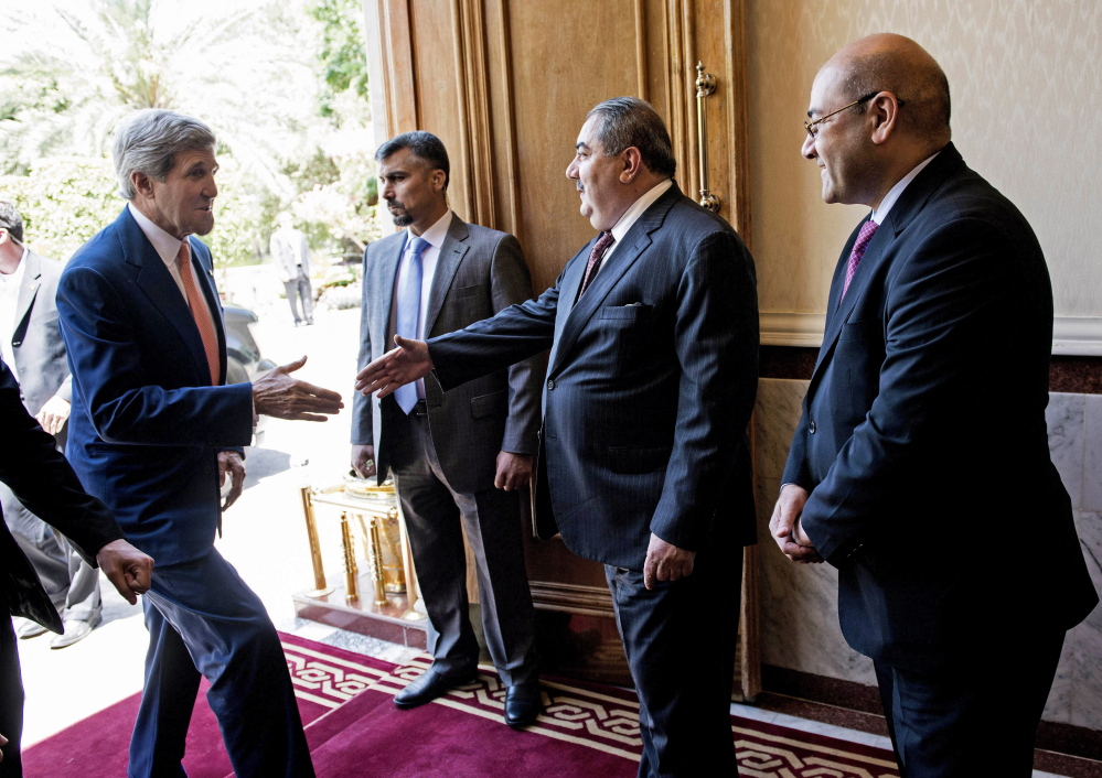 Iraqi Foreign Minister Hoshyar Zebari greets U.S. Secretary of State John Kerry ahead of a meeting at the prime minister’s office in Baghdad Monday.