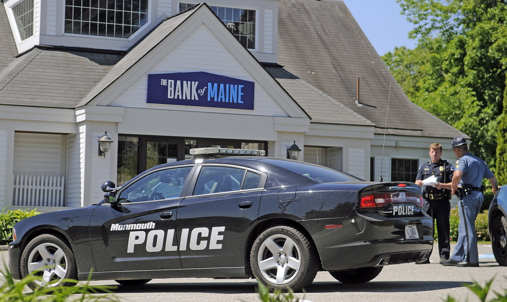 Police confer Monday outside the Bank of Maine branch in Hallowell after it was robbed Monday.