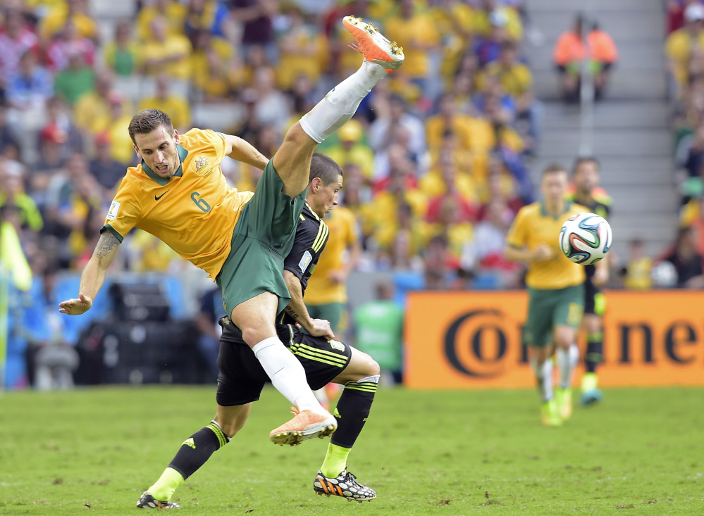 Australia’s Matthew Spiranovic and Spain’s Fernando Torres fight for the ball during the group B World Cup soccer match between Australia and Spain at the Arena da Baixada in Curitiba, Brazil, Monday.