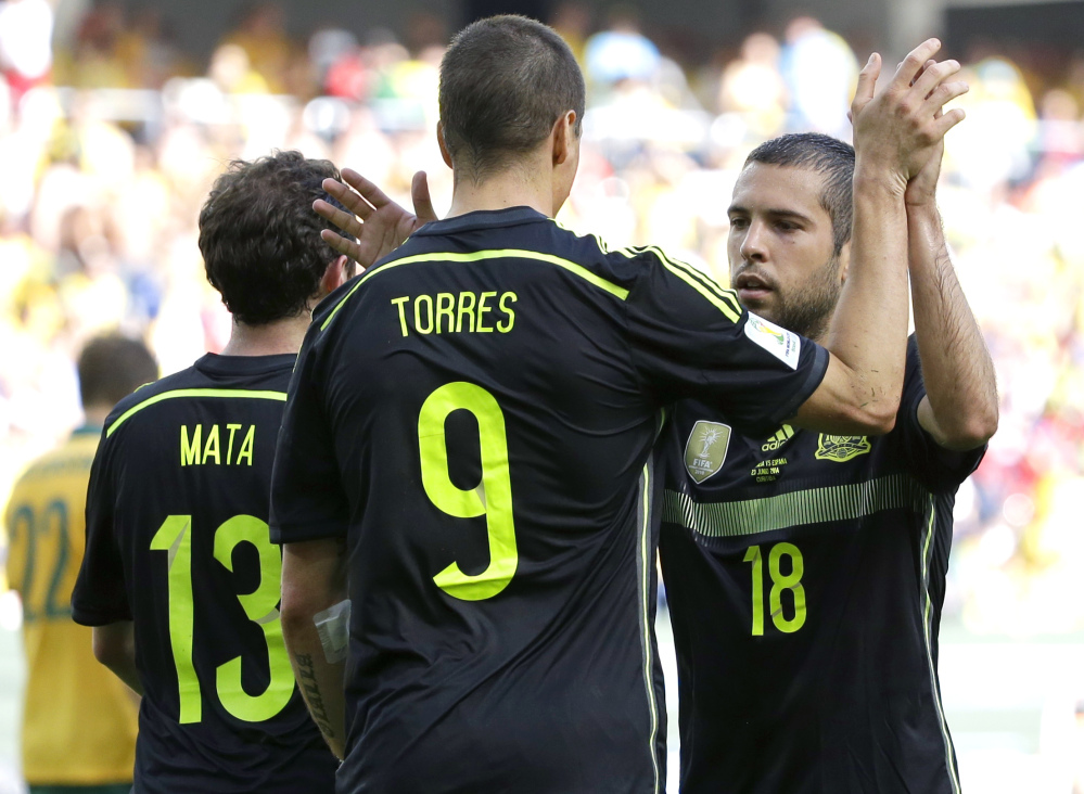Spain’s Fernando Torres, center, celebrates with teammate Jordi Alba after scoring during the group B World Cup soccer match between Australia and Spain at the Arena da Baixada in Curitiba, Brazil, Monday, June 23, 2014.