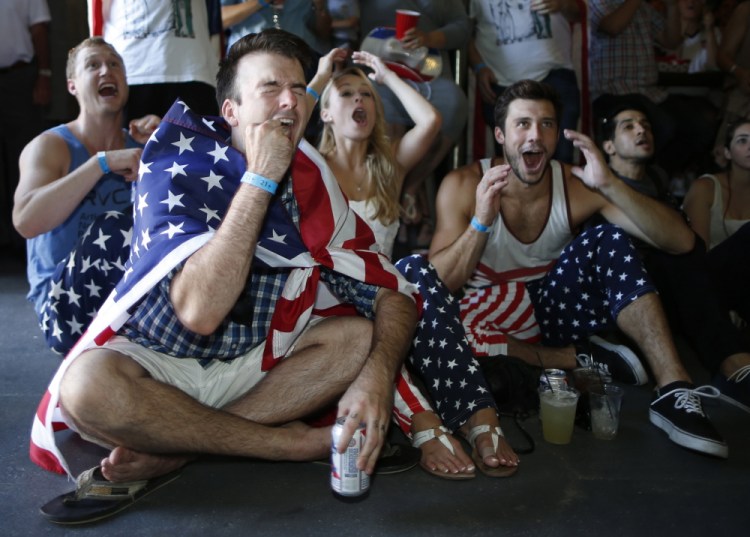 USA soccer fans (L-R) Reid Boutte, 25, McKenzie Anderson, 23, and Andy Shephard, 25, react during the 2014 World Cup Group G soccer match between Portugal and the U.S. at a viewing party in Los Angeles, California, Sunday.