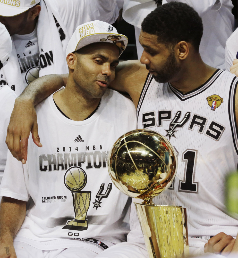 San Antonio Spurs guard Tony Parker, left, and forward Tim Duncan celebrate after Game 5 of the NBA basketball finals on Sunday, June 15, 2014, in San Antonio. The Spurs won their fifth championship in 15 years.