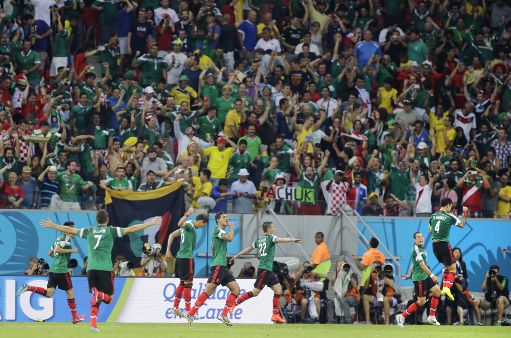 Mexico’s Rafael Marquez, right, celebrates with teammates after scoring the opening goal during the group A World Cup soccer match between Croatia and Mexico in Recife, Brazil, Monday, June 23, 2014.