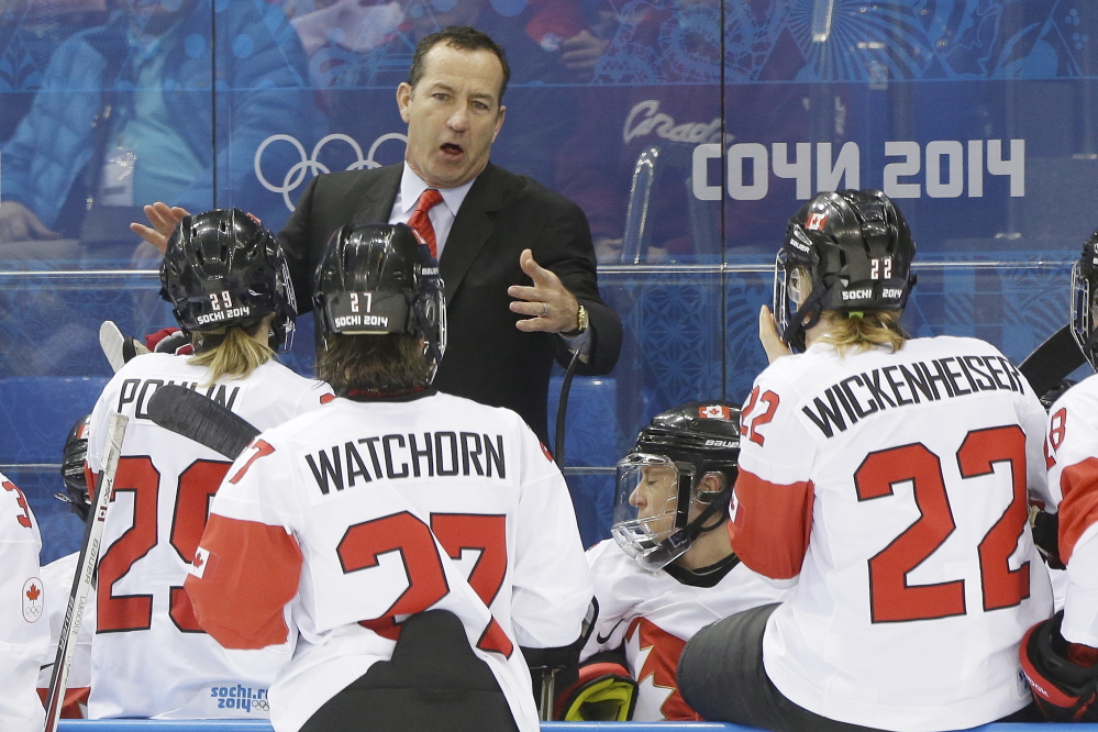 Canada head coach Kevin Dineen talks to the team during a break in the action against Switzerland in the 2014 Winter Olympics women's semifinal hockey game in Sochi, Russia. The Associated Press