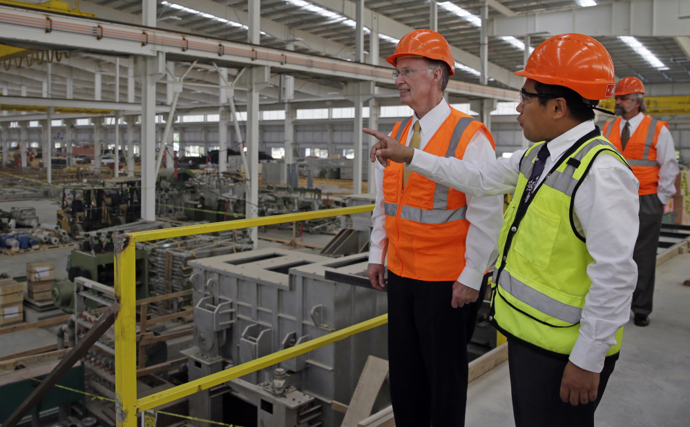 In this August 2013 photo provided by the Alabama Governor’s office, Gov. Robert Bentley, left, listens to Roger Zhang, Golden Dragon U.S.A. President, during a tour of the new Golden Dragon copper tubing plant, then under construction, in Pine Hill, Ala. Golden Dragon, the first company Bentley recruited to Alabama after being elected, will employ 300 new full-time employees in rural Wilcox County.