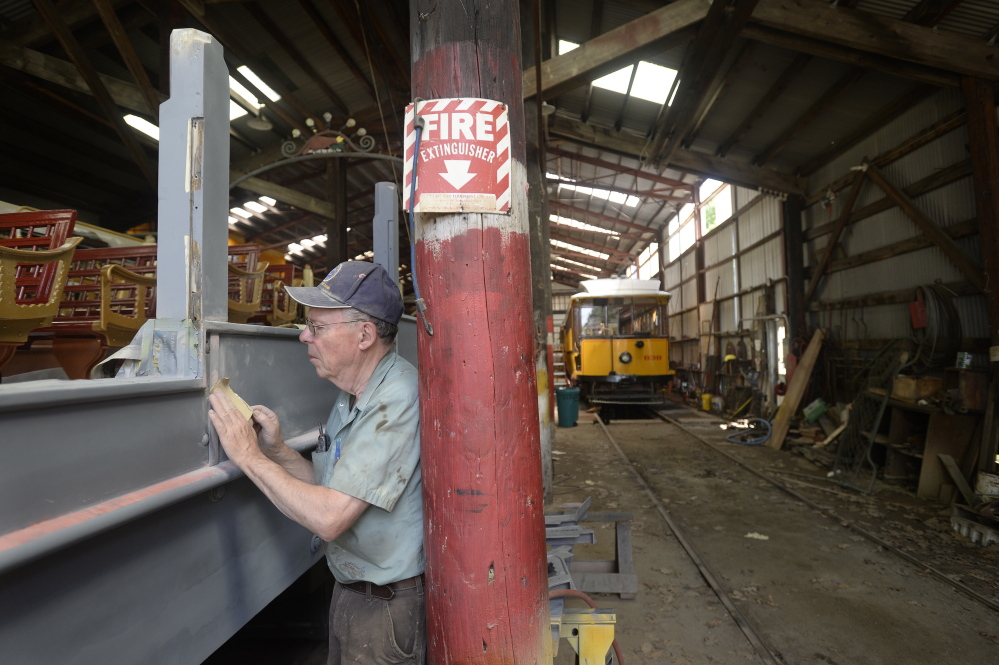 Don Curry, the restoration project manager at the Seashore Trolley Museum, sands the side of the 1906 Montreal “Golden Chariot” observation car at the Seashore Trolley Museum in Kennebunkport on Thursday.