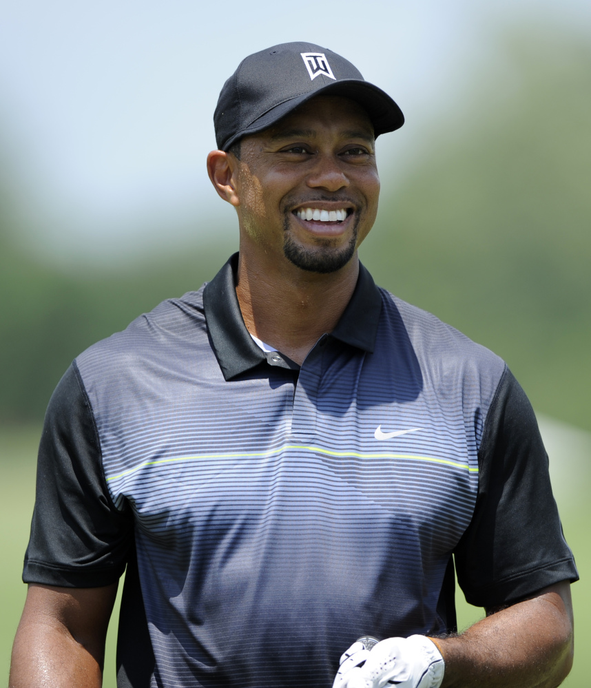 Tiger Woods smiles on the driving range during a practice round for the Quicken Loans National golf tournament, Tuesday, June 24, 2014, in Bethesda, Md.