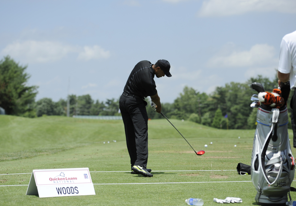 Tiger Woods takes a swing at the driving range during practice round for the Quicken Loans National golf tournament.