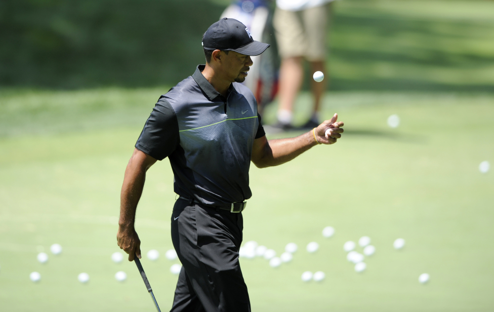 Tiger Woods tosses a ball around during practice for the Quicken Loans National golf tournament, Tuesday, June 24, 2014, in Bethesda, Md.