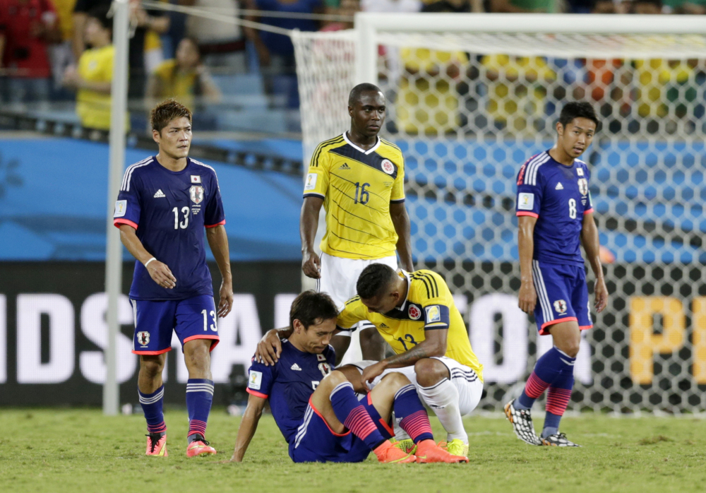 Colombia’s Fredy Guarin, right comforts Japan’s Yuto Nagatomo after the group C World Cup soccer match.