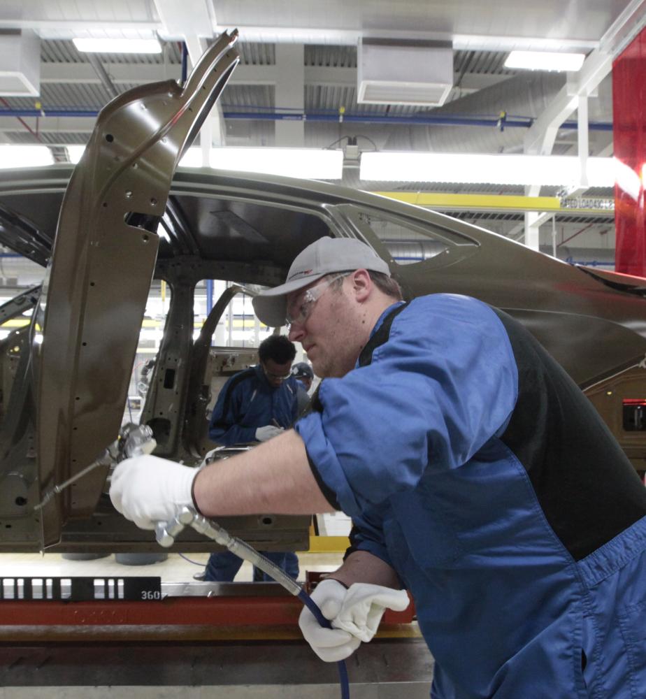 In this March 14, 2014 photo, an assembly line worker works on a 2015 Chrysler 200 automobile at the Sterling Heights Assembly Plant in Sterling Heights, Mich. Most economists agree that the economy last quarter was depressed by temporary factors _ particularly the blast of Arctic chill and snow that shuttered factories, disrupted shipping and kept Americans away from shopping malls and car dealer lots. Since then, the picture has brightened. (AP Photo/Paul Sancya)