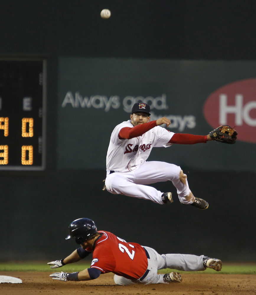 Deven Marrero of Portland leaps over New Hampshire baserunner Kevin Nolan while completing a double-play to end the top of the sixth inning Tuesday in Portland. The Fisher Cats won 5-1. Derek Davis/Staff Photographer