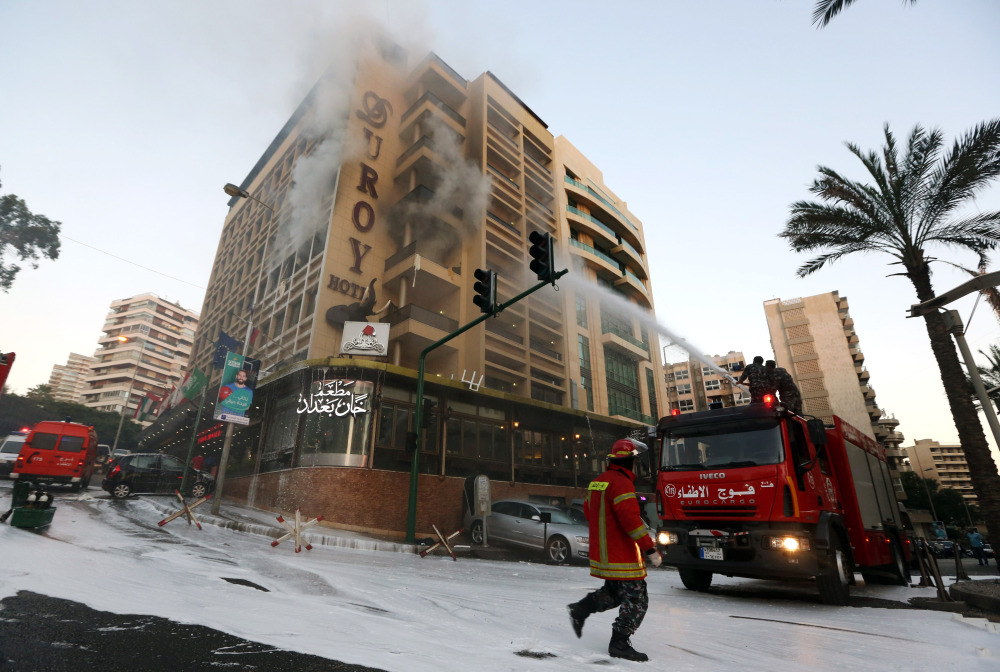 Firefighters work to extinguish a fire after a suicide bomber blew himself up in his room at a Beirut hotel in Lebanon on Wednesday.