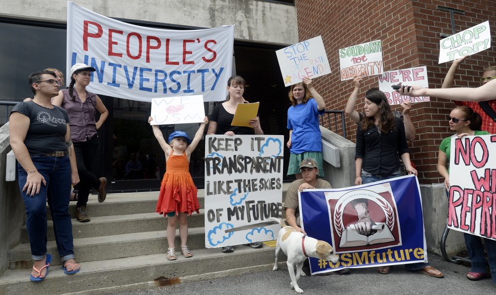 University of Southern Maine student Sarah Victor, center speaks during a protest as her daughter and other protestors hold signs at the University of Southern Maine on Wednesday.