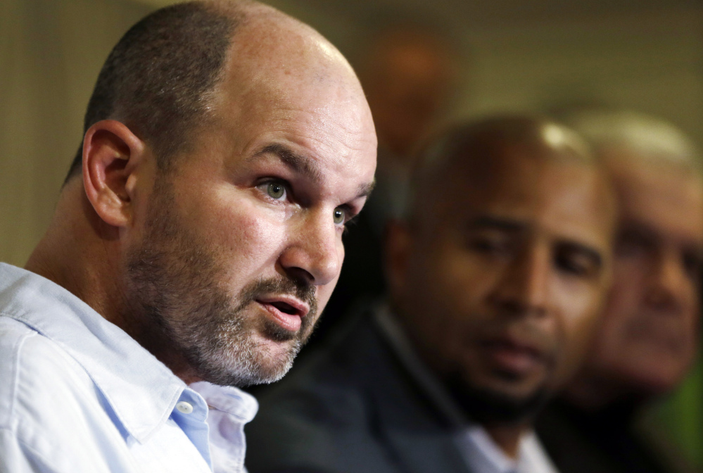 In this April 9, 2013 file photo, former NFL player Kevin Turner, left, speaks during a news conference in Philadelphia, as former players Dorsey Levens, center, and Bill Bergey listen. The NFL agreed Wednesday, June 25, 2014, to remove a $675 million cap on damages from thousands of concussion-related claims after a federal judge questioned whether there would be enough money to cover as many as 20,000 retired players. The plaintiffs include Turner, who played for the Philadelphia Eagles and New England Patriots and is now battling ALS.