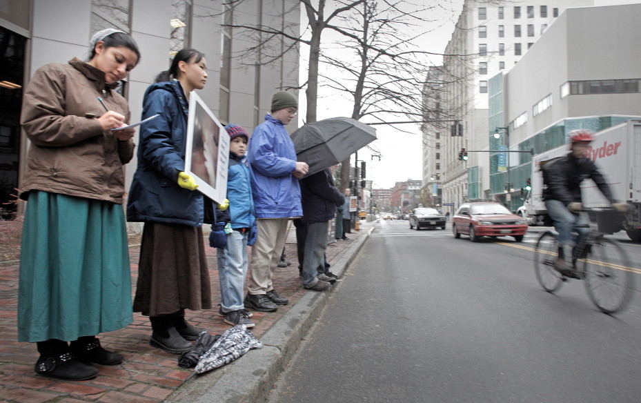 Anti-abortion protesters stand across the street from the Planned Parenthood clinic in Portland on Nov. 22, 2013, the first day they picketed the Congress Street clinic after a 39-foot buffer zone around the clinic took effect.