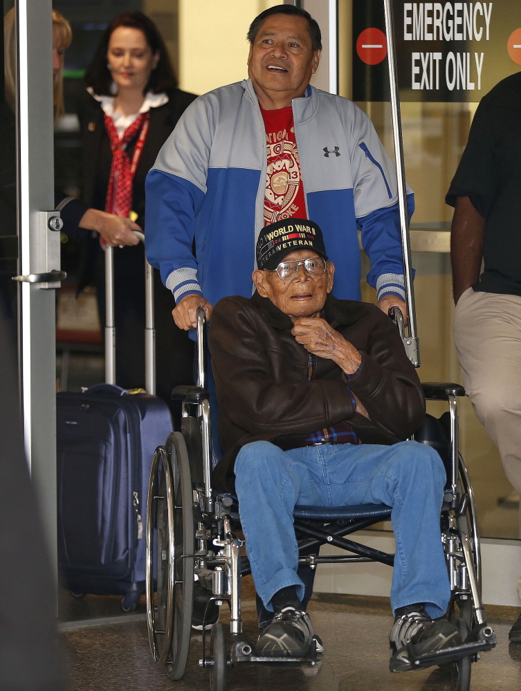 Phillip Coon, a World War II veteran and prisoner of war who survived the Bataan Death March, is pushed in his wheelchair by his son Michael Coon as he returns home from Japan at the Tulsa International Airport in Tulsa, Okla., in 2013. The Muscogee Creek Nation says tribal member Phillip Coon died Monday in Tulsa. Coon was the last remaining Native American survivor of the Bataan Death March, where thousands of soldiers were forced on a 65-mile trek by the Japanese military.