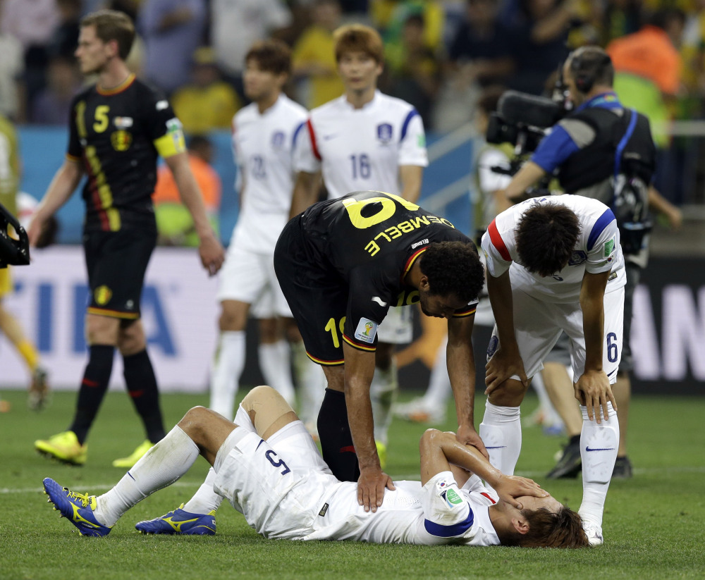 Belgium’s Mousa Dembele helps console South Korea’s Kim Young-gwon following Belgium’s 1-0 victory over South Korea during the group H World Cup soccer match at the Itaquerao Stadium in Sao Paulo, Brazil, on Thursday.
