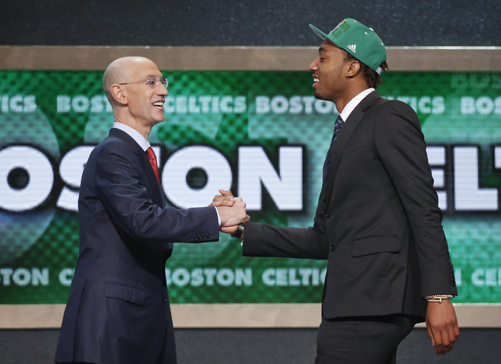 Kentucky's James Young, right, is greeted by NBA Commissioner Adam Silver after being selected as the 17th overall pick by the Boston Celtics during the 2014 NBA draft, Thursday, June 26, 2014, in New York. (AP Photo/Jason DeCrow)